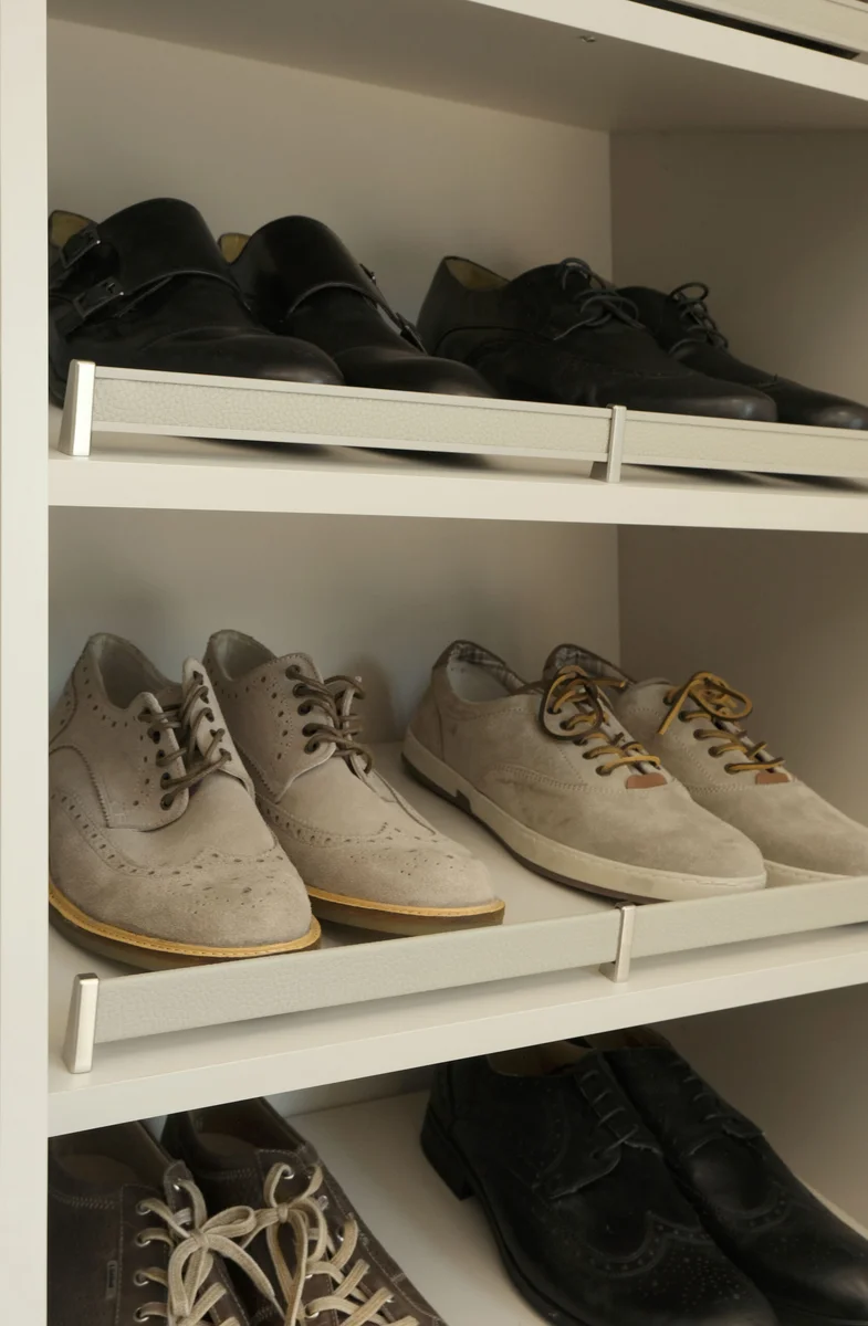 Shoes displayed behind upholstered shelf fences